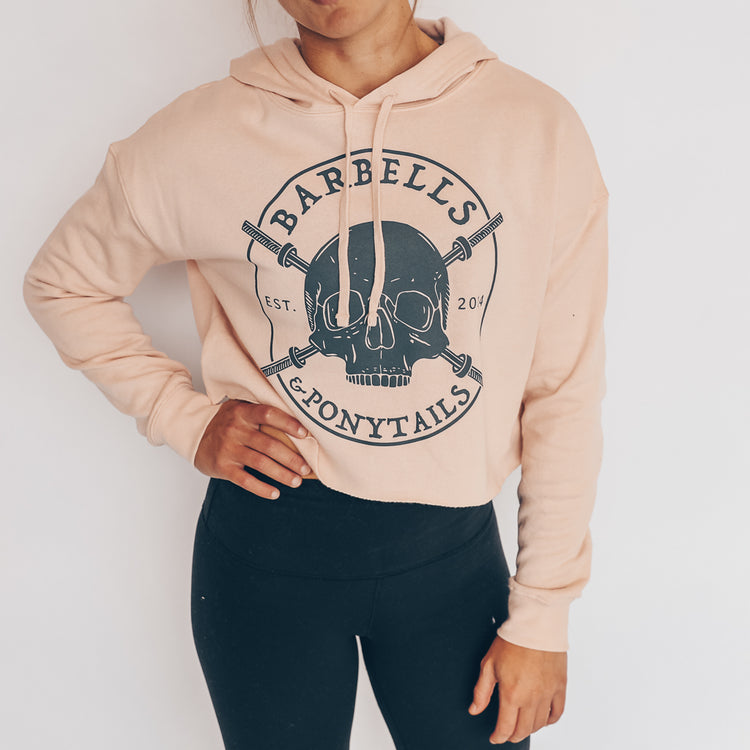 blush crop hoodie with grey skulls and barbells design