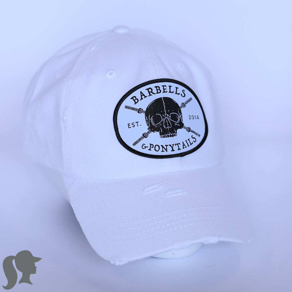 solid white ponytail hat with skulls and barbells text