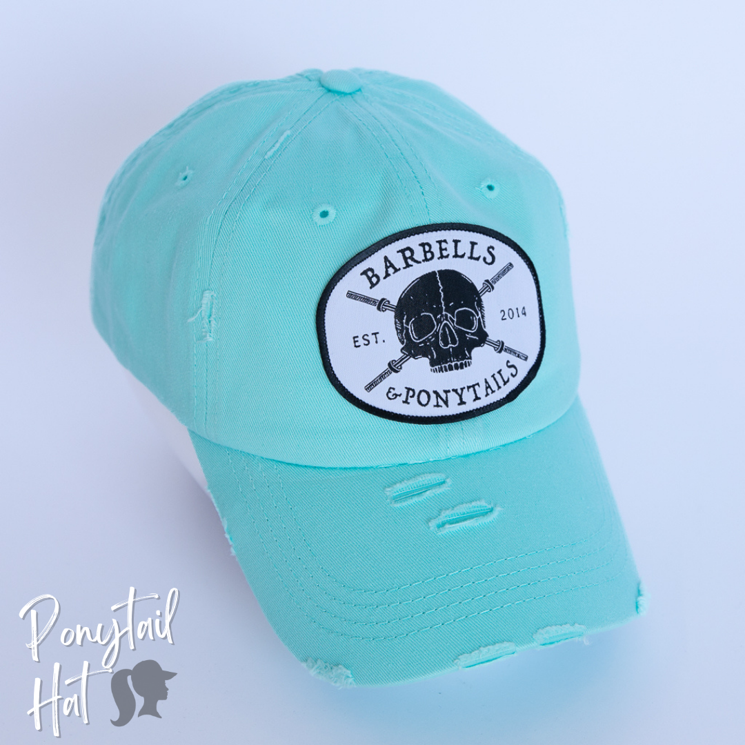 solid light blue ponytail hat with skulls and barbells text